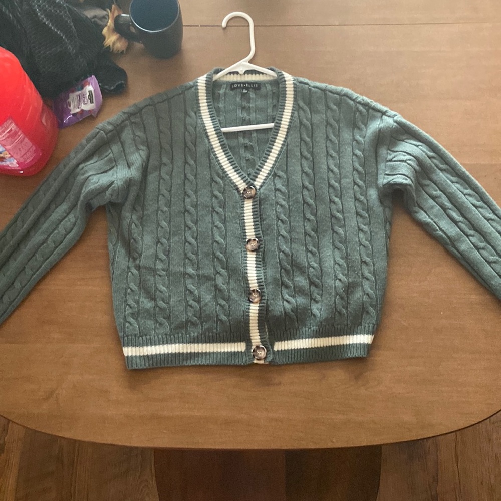 An sage green and white button up sweater